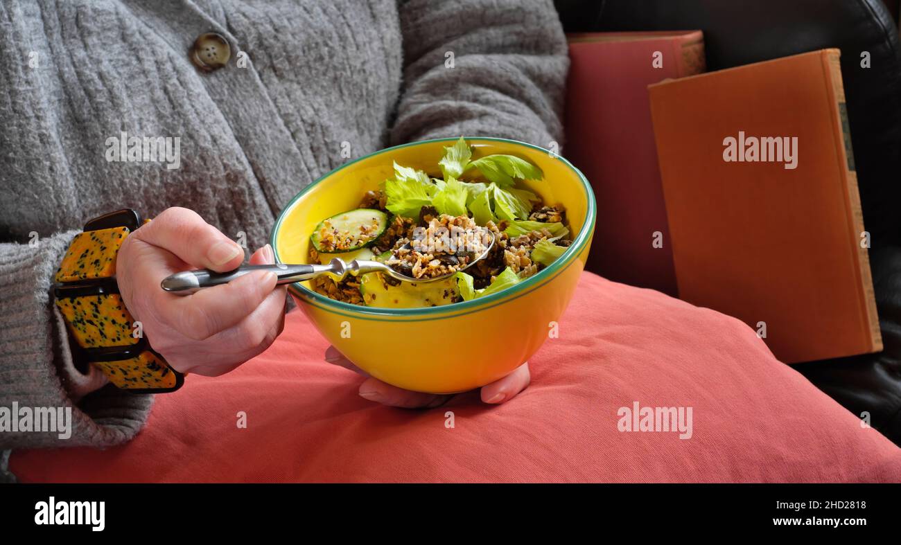 Donna in calda ciotola di tenuta maglione con fresco e sano pranzo vegetariano a base di cereali. Muesli e verdure, mangiare sano, vegano, dieta, concetto di cibo Foto Stock