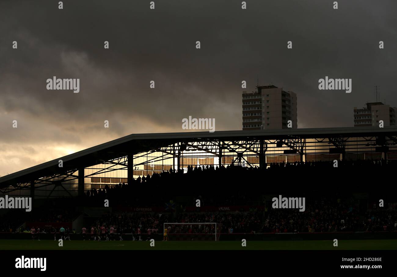 Vista generale mentre il sole tramonta dietro i tifosi di Brentford negli stand durante la partita della Premier League al Brentford Community Stadium di Londra. Data foto: Domenica 2 gennaio 2022. Foto Stock