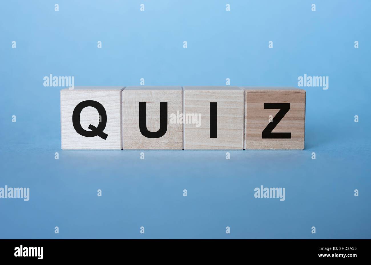 QUIZ di parole su cubi di legno su sfondo blu chiaro Foto Stock