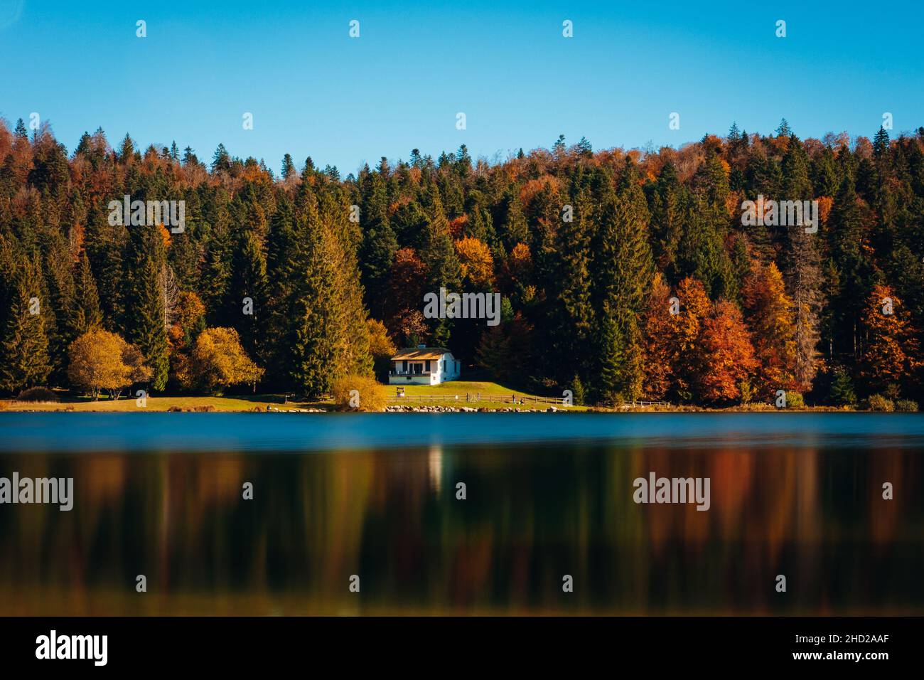 Magnifica vista di una casa solitaria sul lago scenico vicino alla foresta d'autumforest Foto Stock