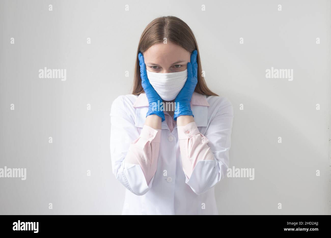 Il medico ha scioccato. Ritratto medico femminile o infermiere in paura e shock in maschera medica e guanti Foto Stock