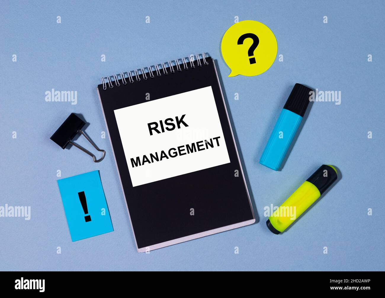 Nota sulla gestione dei rischi scritta su un notebook con note a matita e graffetta. Business concept blu e giallo brillante Foto Stock