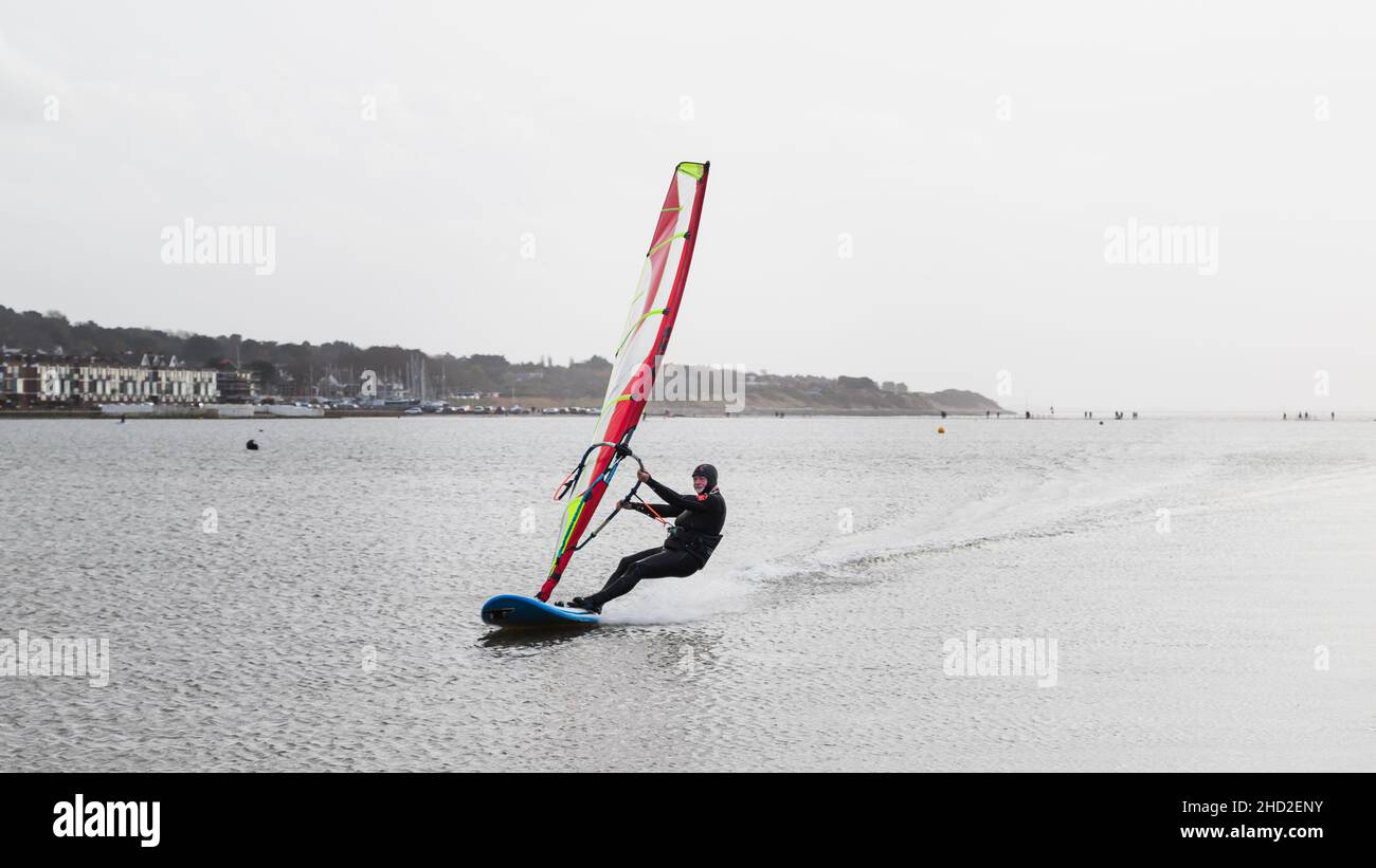 Un uomo vento surf intorno al bordo del lago marino a West Kirby visto il 1 gennaio 2022. Foto Stock