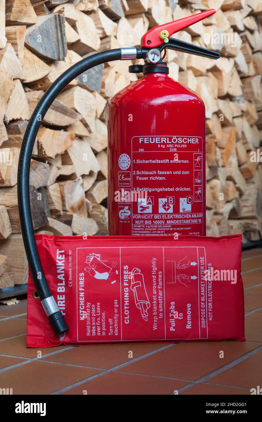 estintore e coperta, cumulo di legno nel backgorund Foto Stock