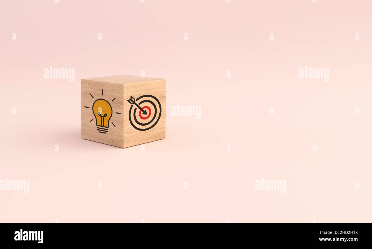 Blocco cubo di legno con icona target e lampadina su sfondo rosa. Concetto di strategia aziendale. 3D illustrazione. Foto Stock