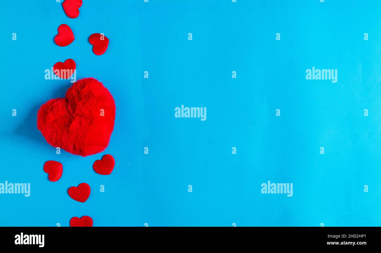 Forma a cuore rosso isolata su sfondo blu per la cura, l'amore, tema valentine Foto Stock