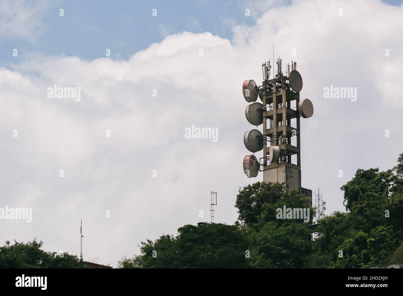 Bella vista della torre di comunicazione sotto il cielo nuvoloso blu Foto Stock