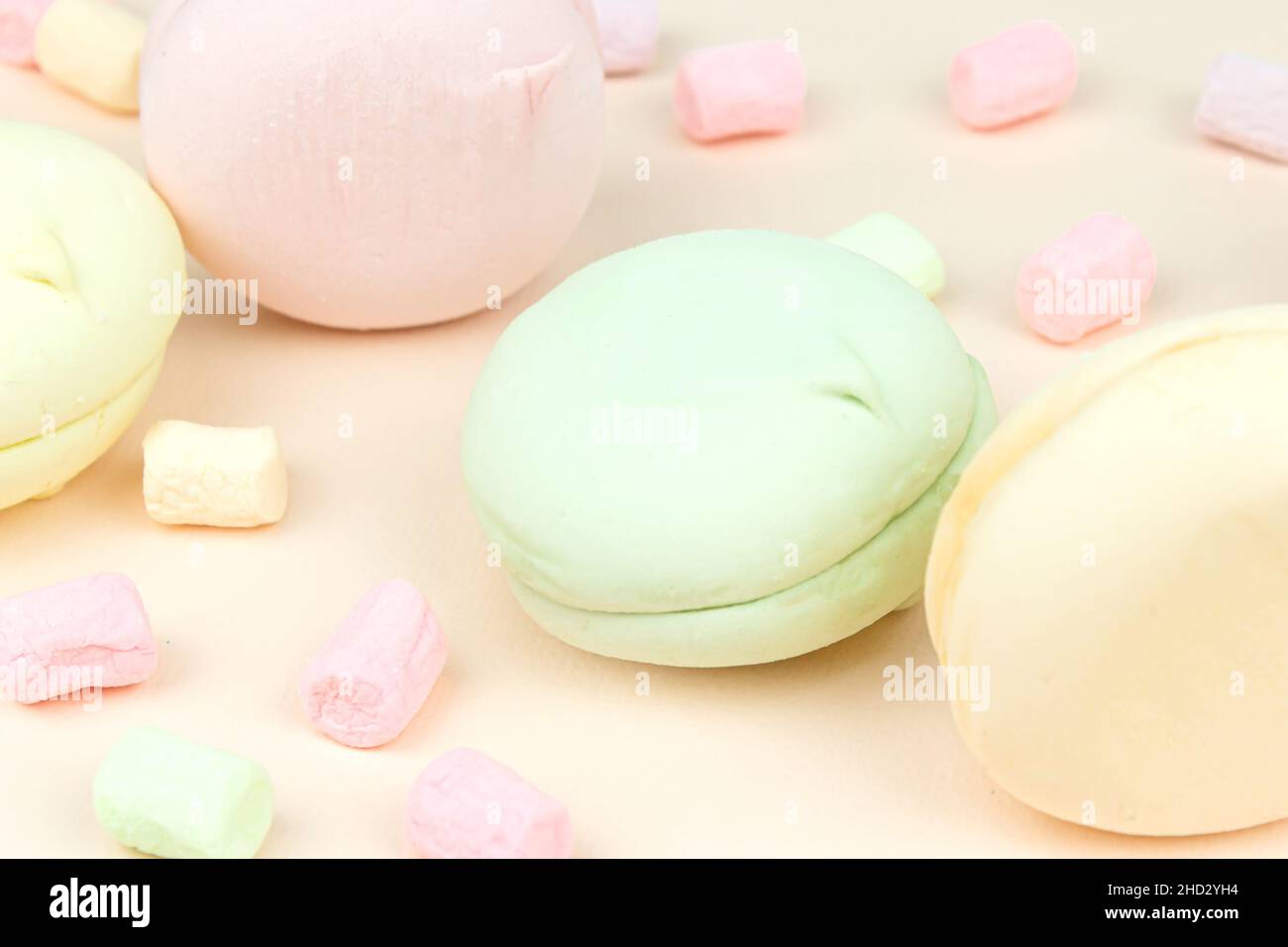 Deliziosi macaroni Marshmallow colorati e dolci. Bella varietà di amaretti su sfondo rosa pastello Foto Stock