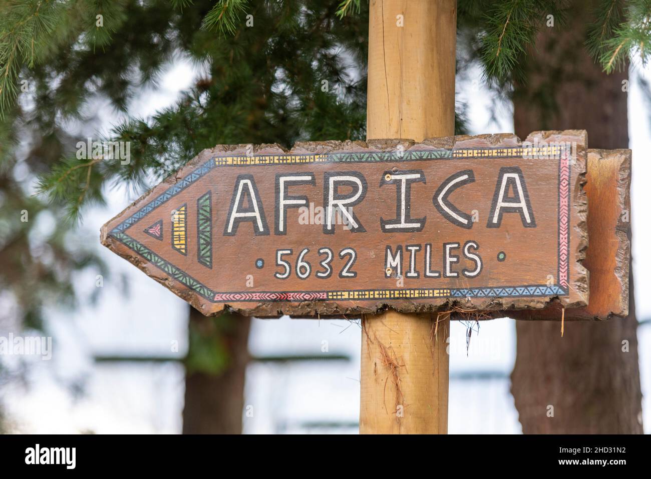 Insegna di stile africano che indica Africa a 5632 miglia dal Regno Unito. Distanza di viaggio tra i continenti Foto Stock