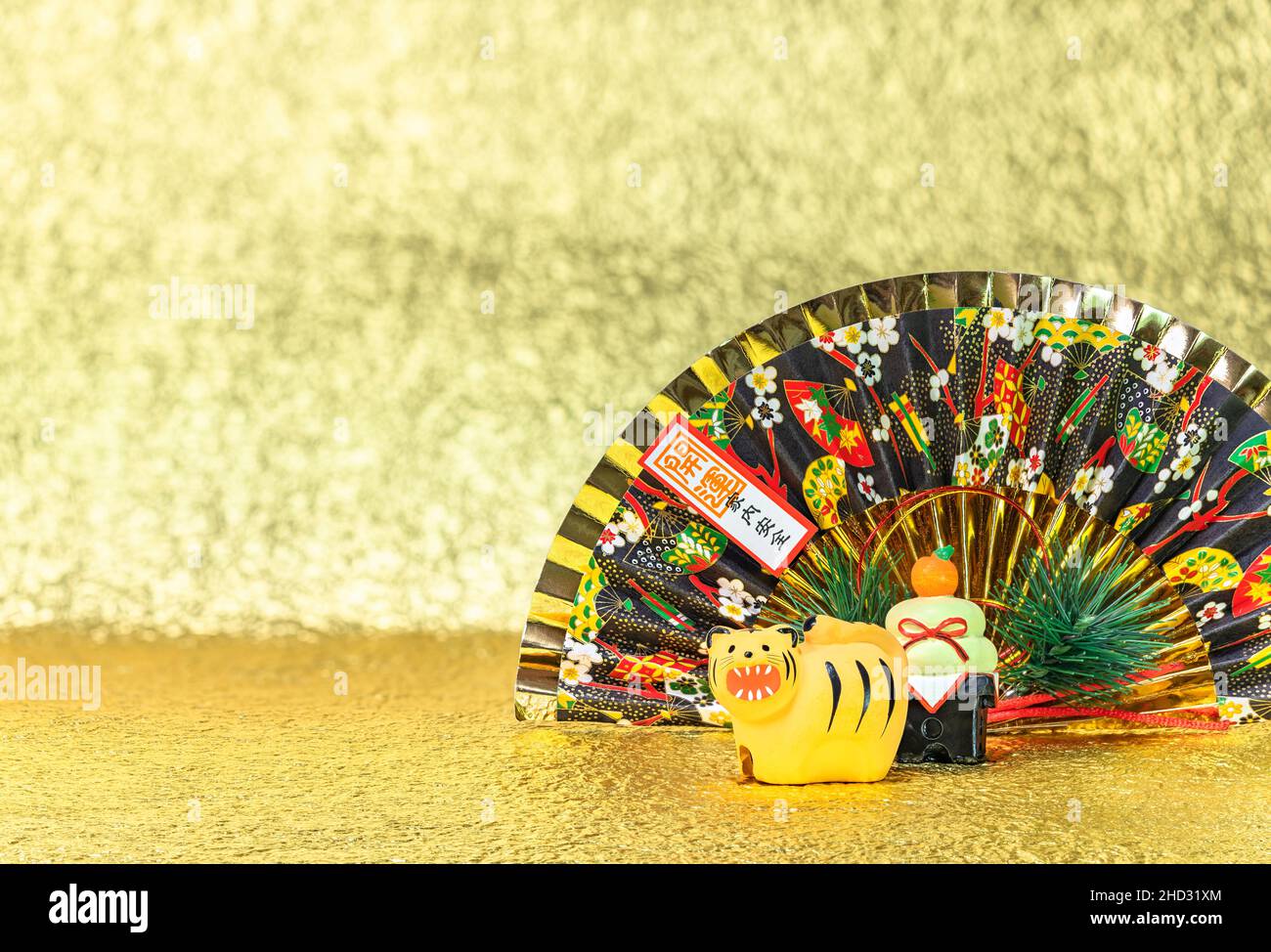 Biglietto di auguri per il Capodanno giapponese di una divertente figurina di tigre ruggente per l'anno 2022 con un ventilatore pieghevole scritto buona fortuna per una casa sicura contro a. Foto Stock