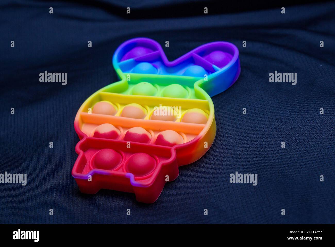 Giocattolo colorato pop it a forma di coniglio su sfondo nero a Rio de Janeiro. Foto Stock