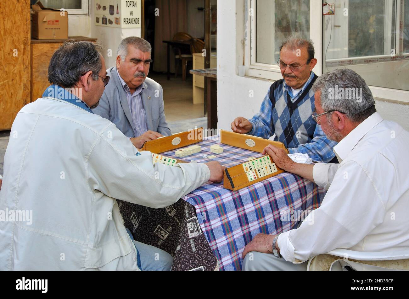 Uomini che giocano a Okey (tradizionale gioco da tavolo turco) all'esterno del caffè, Bodrum, provincia di Mugla, Repubblica di Türkiye Foto Stock