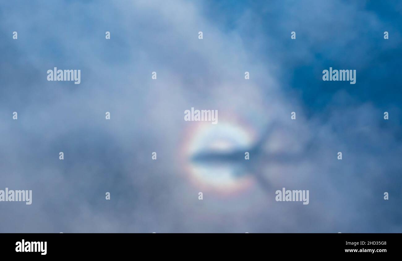 L'alone arcobaleno dell'ombra dell'aereo sulle nuvole e sull'oceano, preso dall'aereo. Foto Stock