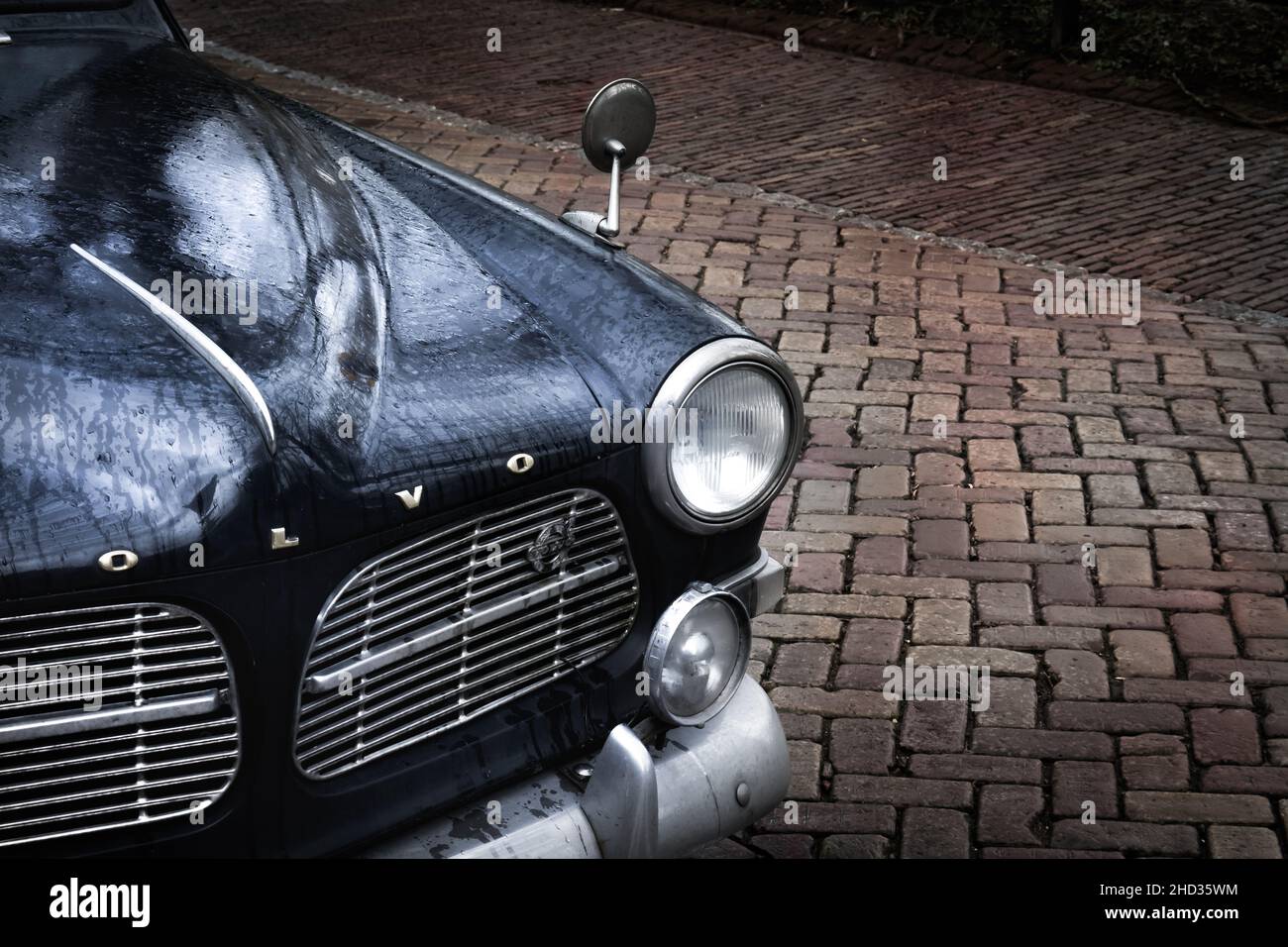 Primo piano di un'auto nera d'epoca sotto la pioggia Foto Stock