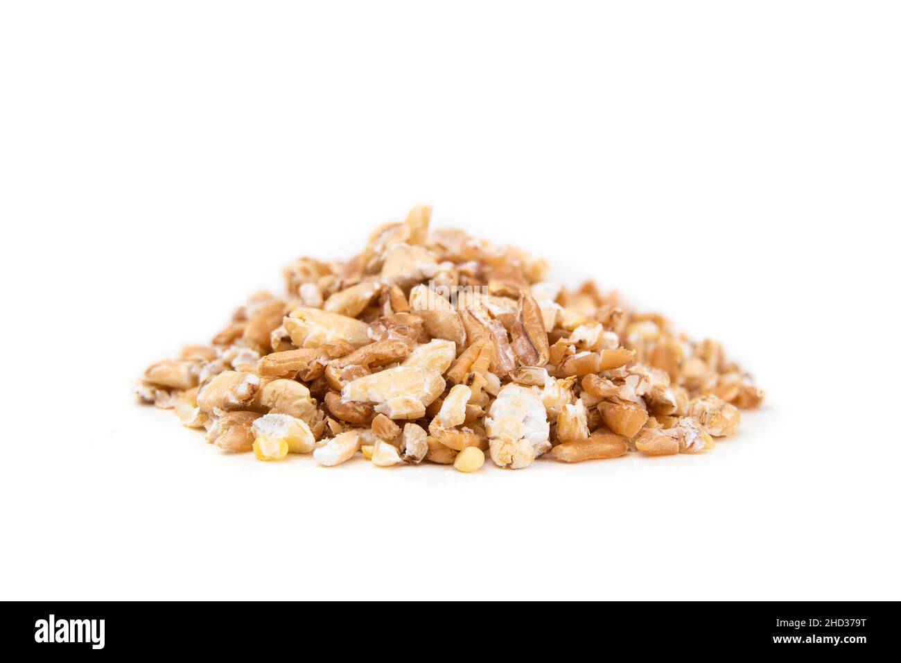 Fiocchi di grani in un mucchio, primo piano. Macro di cereali misti in fiocchi e non imbevuti, fatti con un sfornatore di grano o un mulino di grano. Chicchi di grano duro, sorgo Foto Stock