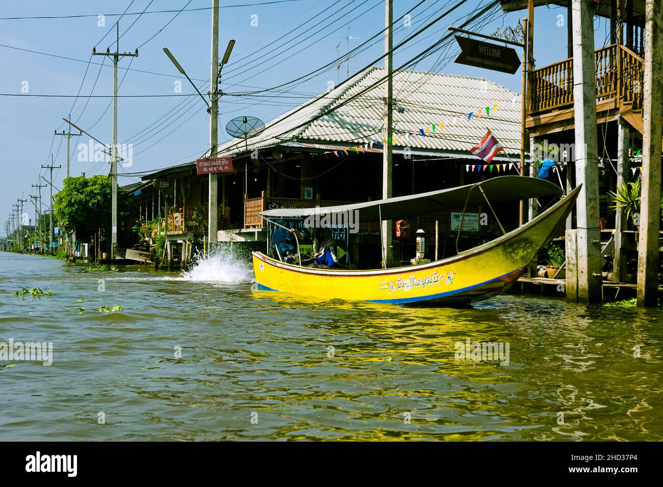 Damnoen Saduak: Un motoscafo giallo a coda lunga che porta il passeggero per un tour del mercato galleggiante fuori Bangkok. Foto Stock