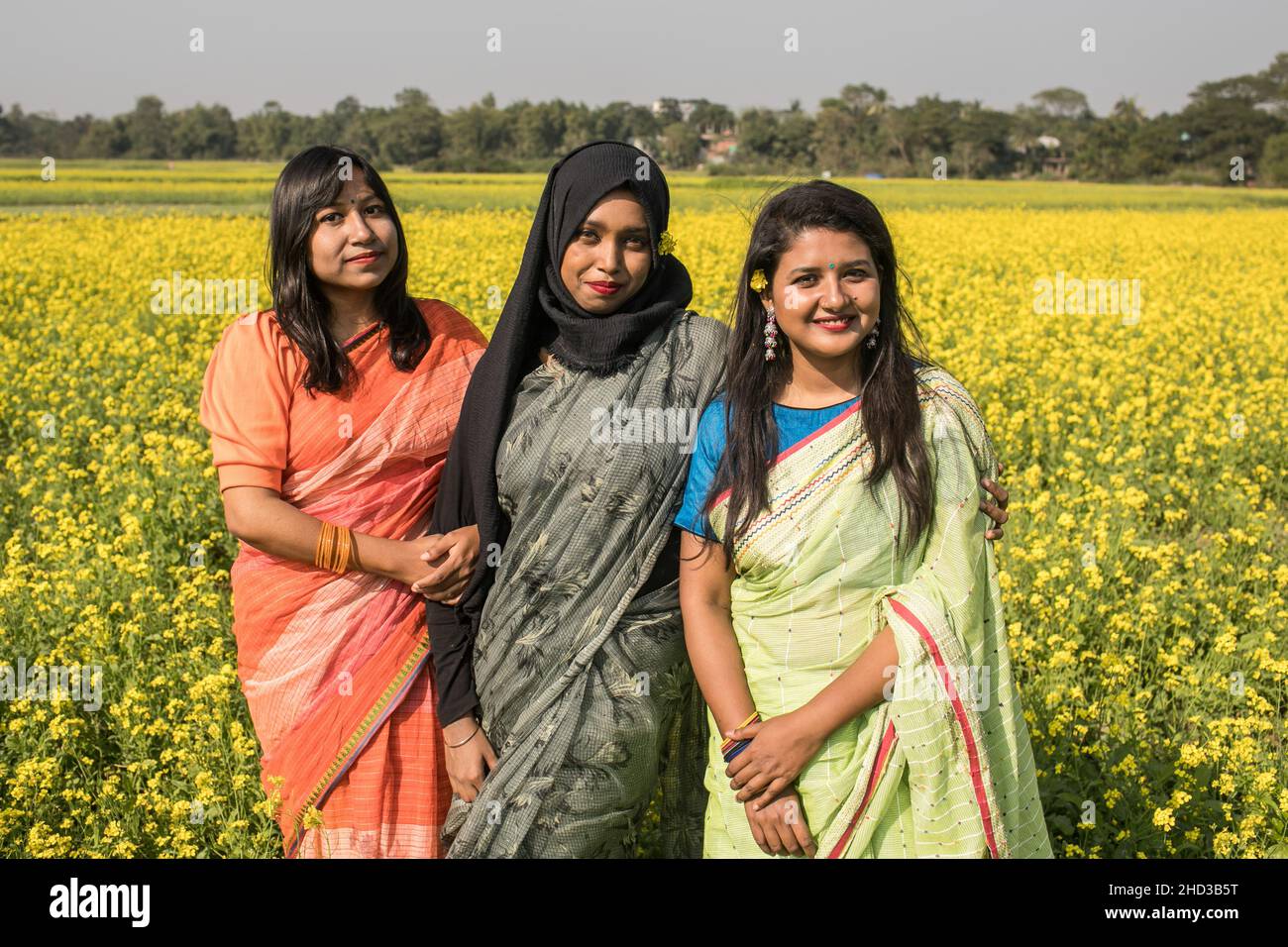 Dhaka, Bangladesh. 31st Dic 2021. Le donne posano per una foto in un campo di senape giallo alla periferia di Dhaka. La senape è un raccolto freddo di tempo ed è coltivata dai semi seminati in primavera. Da metà dicembre fino alla fine di gennaio, gli agricoltori del Bangladesh coltivano le loro colture di fiori di senape gialli dai colori vivaci che sono in piena fioritura. (Foto di Sazzad Hossain/SOPA Images/Sipa USA) Credit: Sipa USA/Alamy Live News Foto Stock