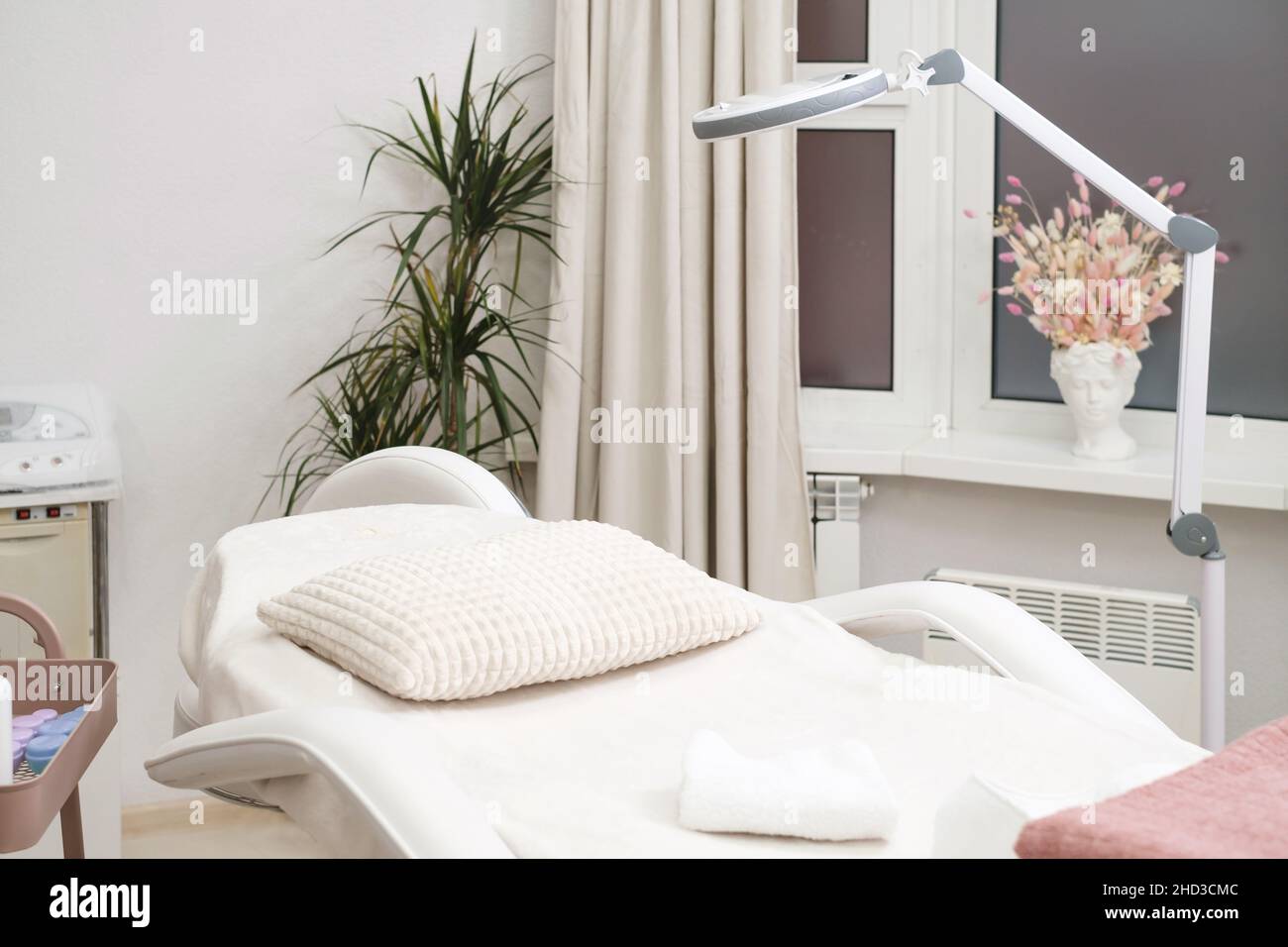 Moderna e vuota tavola di massaggio cosmetologo cosmetologo per le procedure cosmetiche nella clinica di bellezza. Salone di medicina estetica vuoto Foto Stock