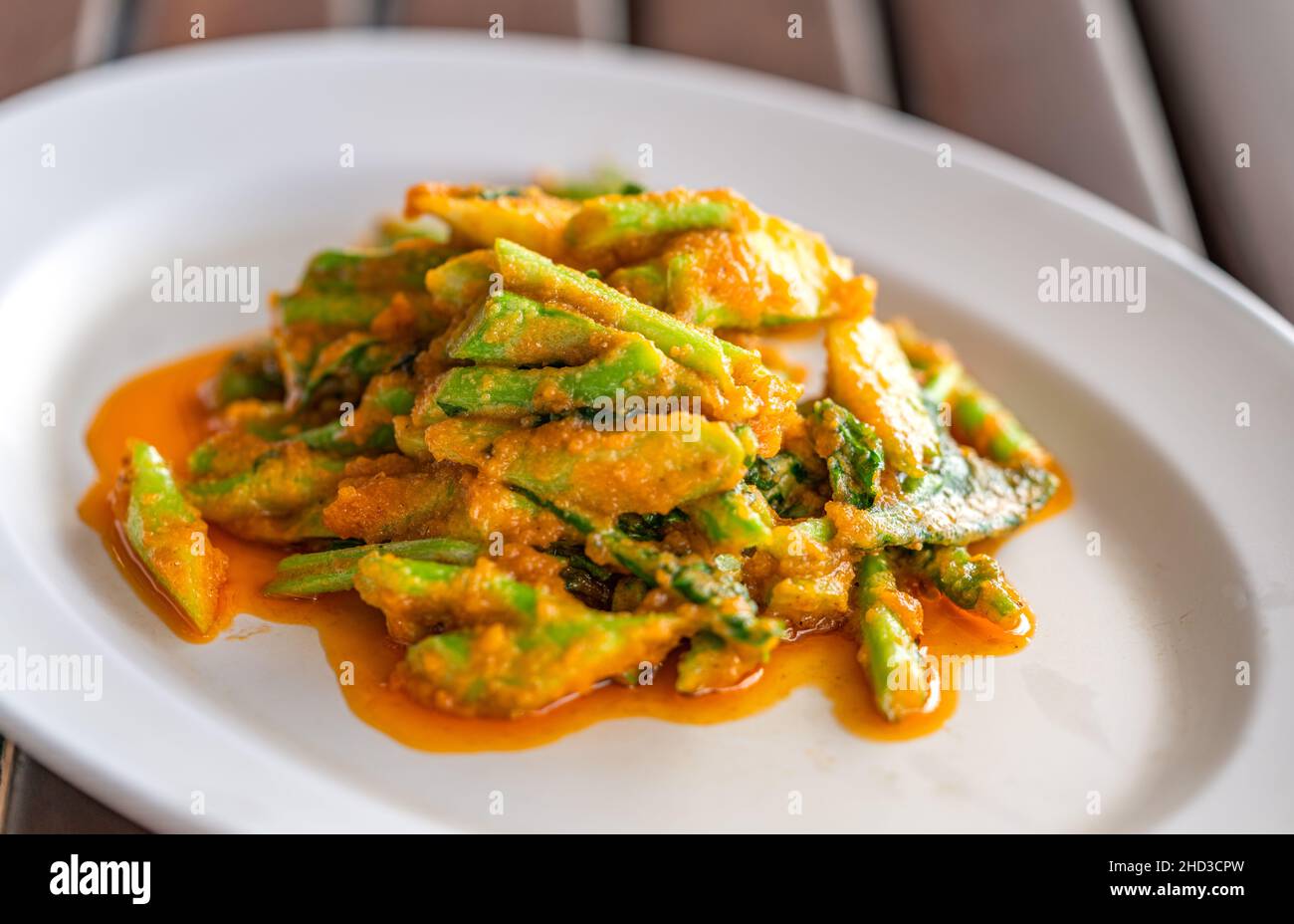 Mescolare Kale fritto o broccoli cinesi con uovo salato in piatto bianco su tavola di legno, primo piano immagine cibo tailandese di broccoli cinesi con uovo salato, natura Foto Stock