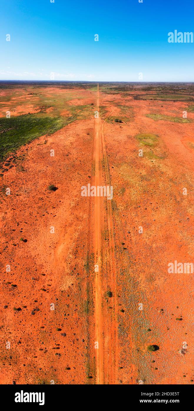 Infinite pianure dell'entroterra australiano semi deserto intorno a collina rotta in verticale panorama aereo lungo la pista sterrata. Foto Stock