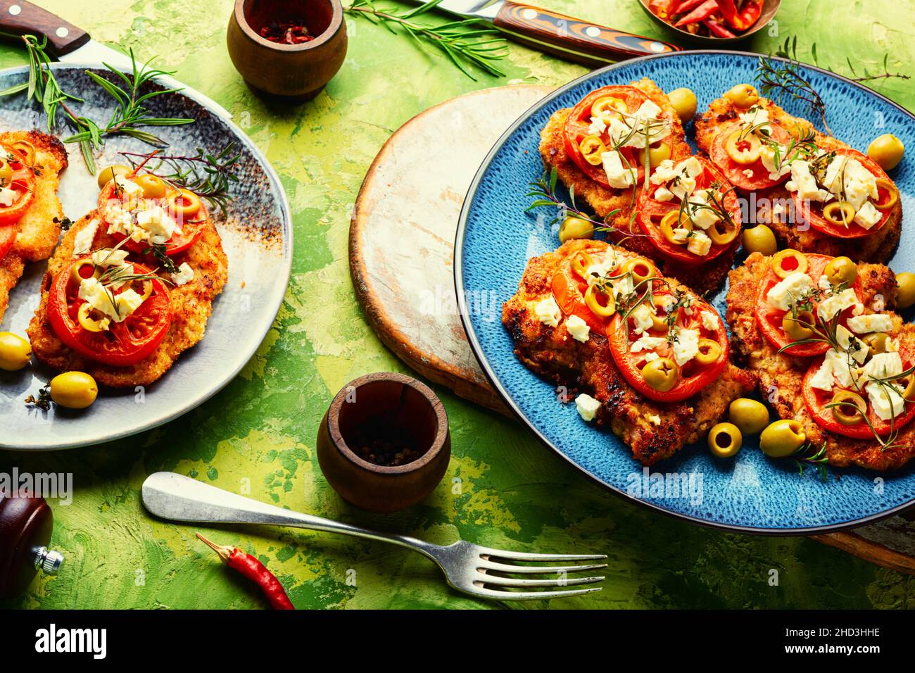 Sottile strato di carne, impanato in pangrattato con formaggio, olive e pomodoro. Piatto di carne - schnitzel Foto Stock