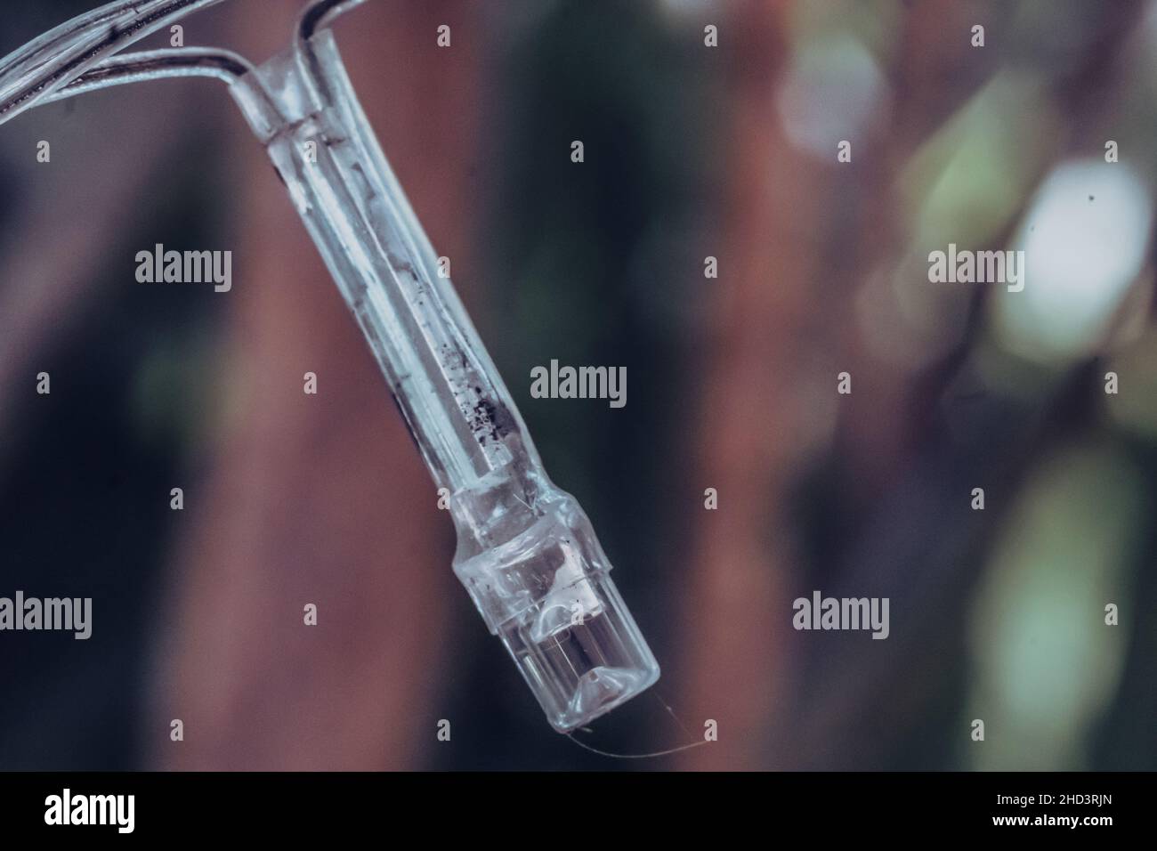 Macro primo piano vecchio piccolo bruciato bianco plastica pallida diodo ad emissione luminosa LED striscia di lampada di ghirlanda elettrica. Sfocatura dello sfondo. Oggetto esterno Foto Stock