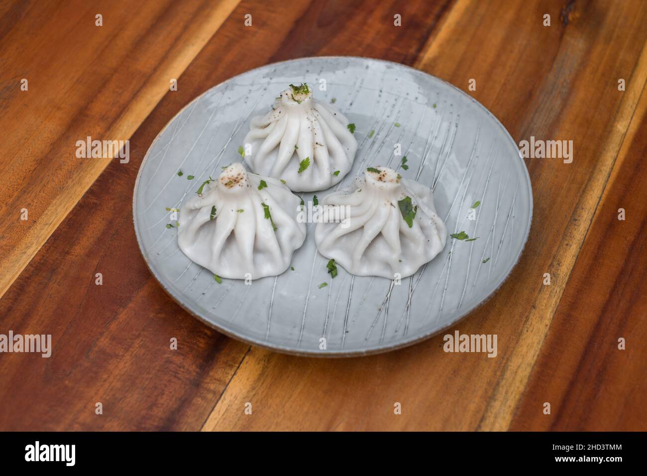 Cucina nazionale georgiana. Khinkali con carne. Khinkali su un piatto su sfondo di legno. Vista dall'alto, da vicino con spazio di copia. Foto di alta qualità Foto Stock