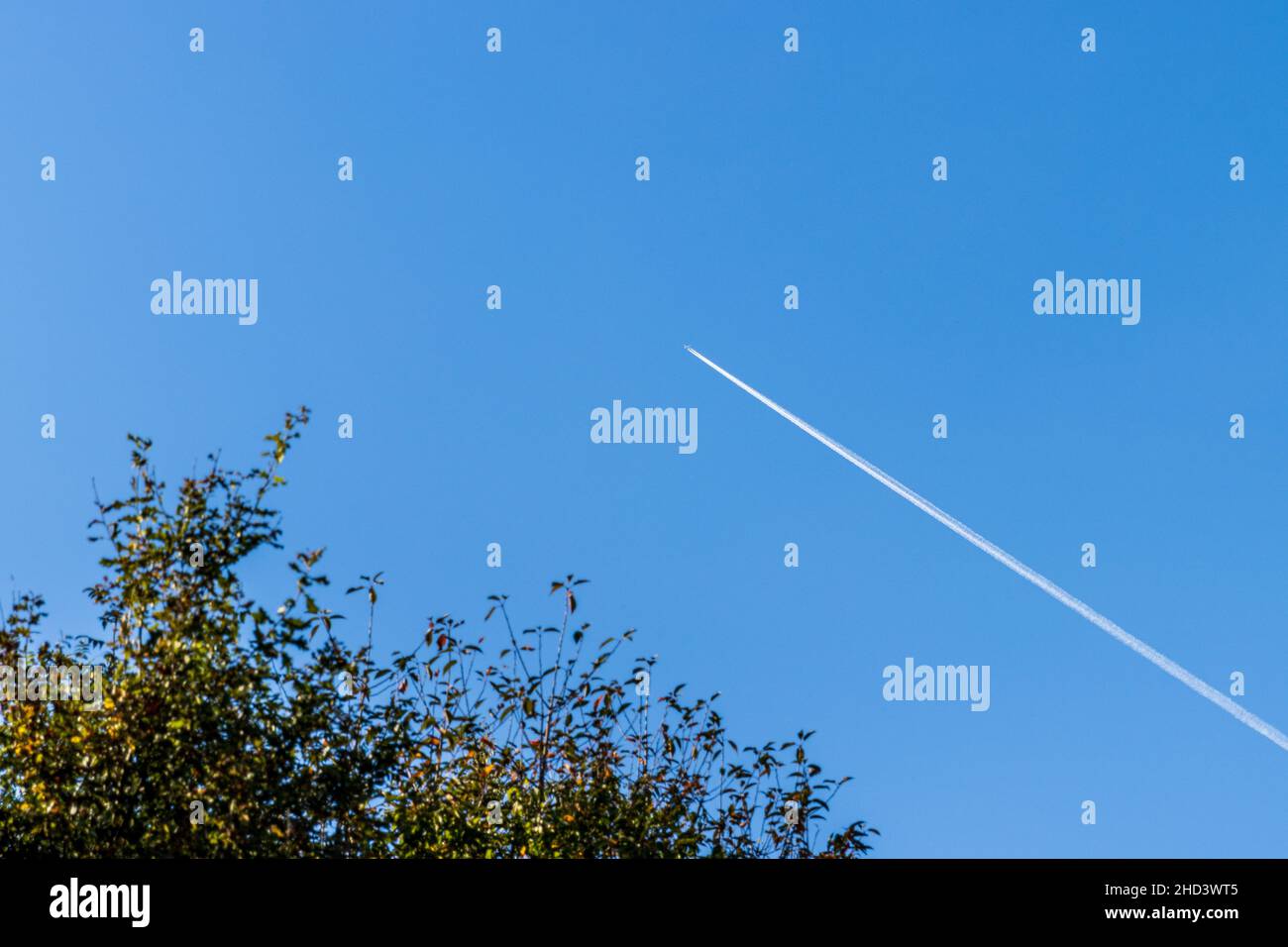 Bellissimo scatto di un aereo volante lasciando linee bianche Foto Stock