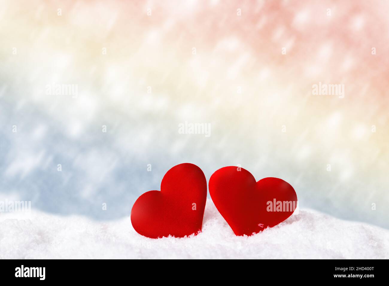 Concetto di San Valentino. Due cuori rossi di neve bianca su sfondo sfocato con spazio per la copia Foto Stock