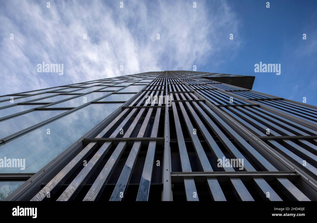 Nuvole che passano sopra grattacielo di vetro Foto Stock