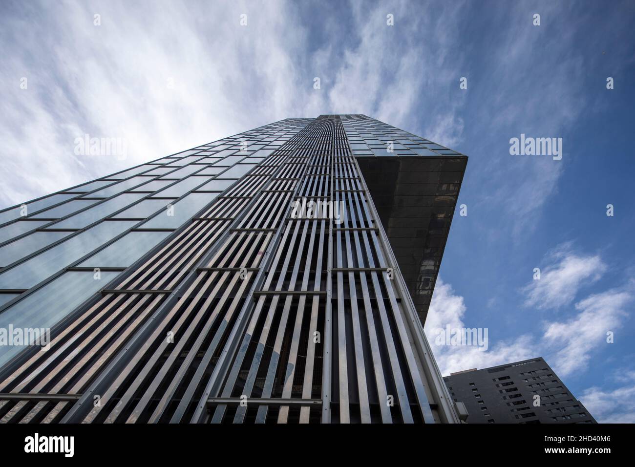 Nuvole che passano sopra grattacielo di vetro Foto Stock