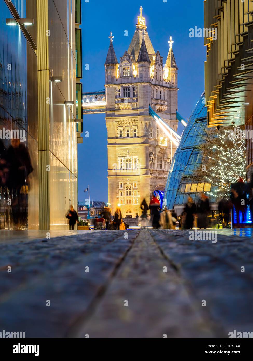 Il famoso Tower Bridge, vista da una strada stretta nella città di Londra al tramonto, in Inghilterra - Regno Unito Foto Stock