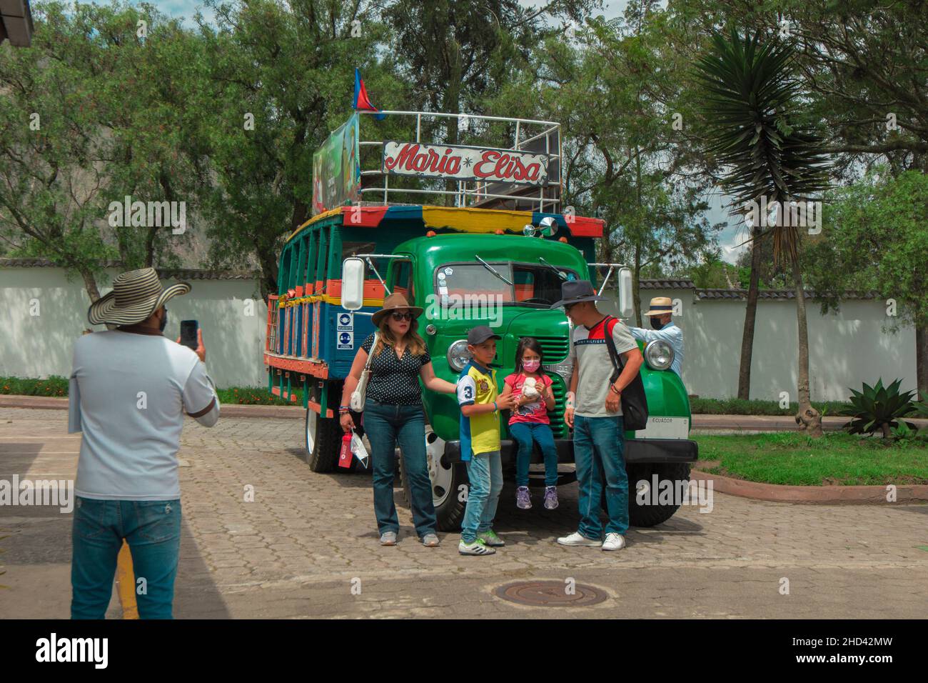 San Antonio de Pichincha, Pichincha, Ecuador - Dicembre 4 2021: Gruppo di turisti che prendono selfie accanto ad un tipico Chiva, un camion decorato utilizzato come a. Foto Stock