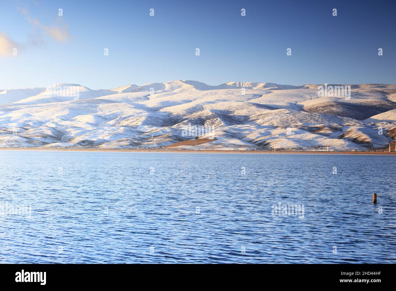 Vista panoramica del Lago Qinghai circondato da colline innevate in Cina Foto Stock