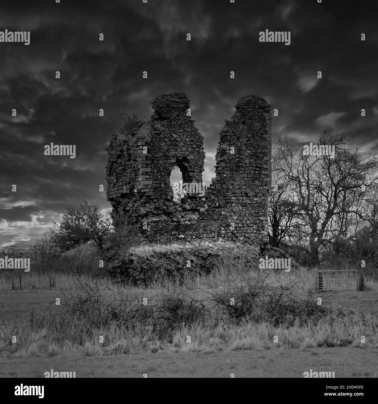 Le antiche rovine del castello Auchenharvie vicino al villaggio di Torranyard nel Nord Ayrshire. In bianco e nero per un'atmosfera suggestiva. Foto Stock