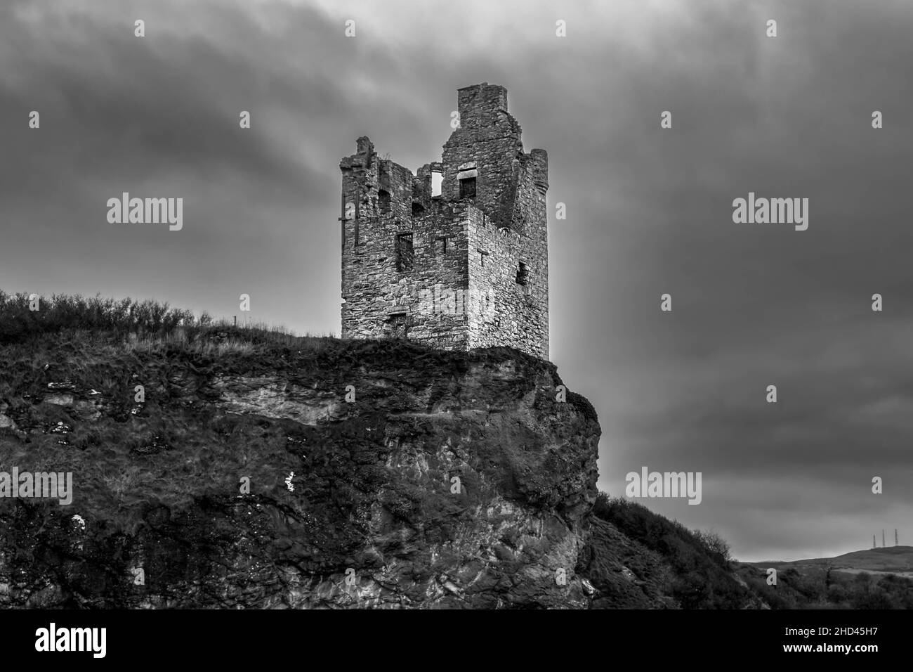 Antiche rovine di ciò che è rimasto del Castello di Greenan arroccato precariamente vicino al bordo della scogliera di fronte a Ayr Scozia con la pietra quasi mile Foto Stock