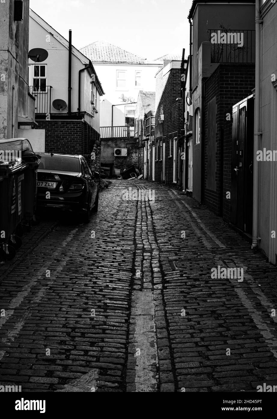 Foto verticale di una strada stretta circondata da edifici, immagine in scala di grigi, Eastbourne Foto Stock