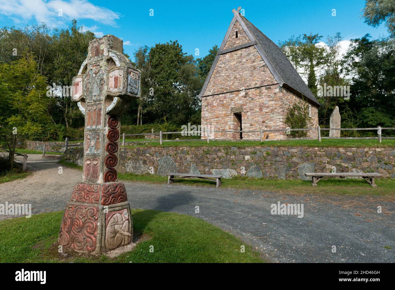Bellissimo scatto di una croce paleocristiana e di una chiesa nel patrimonio nazionale irlandese Foto Stock