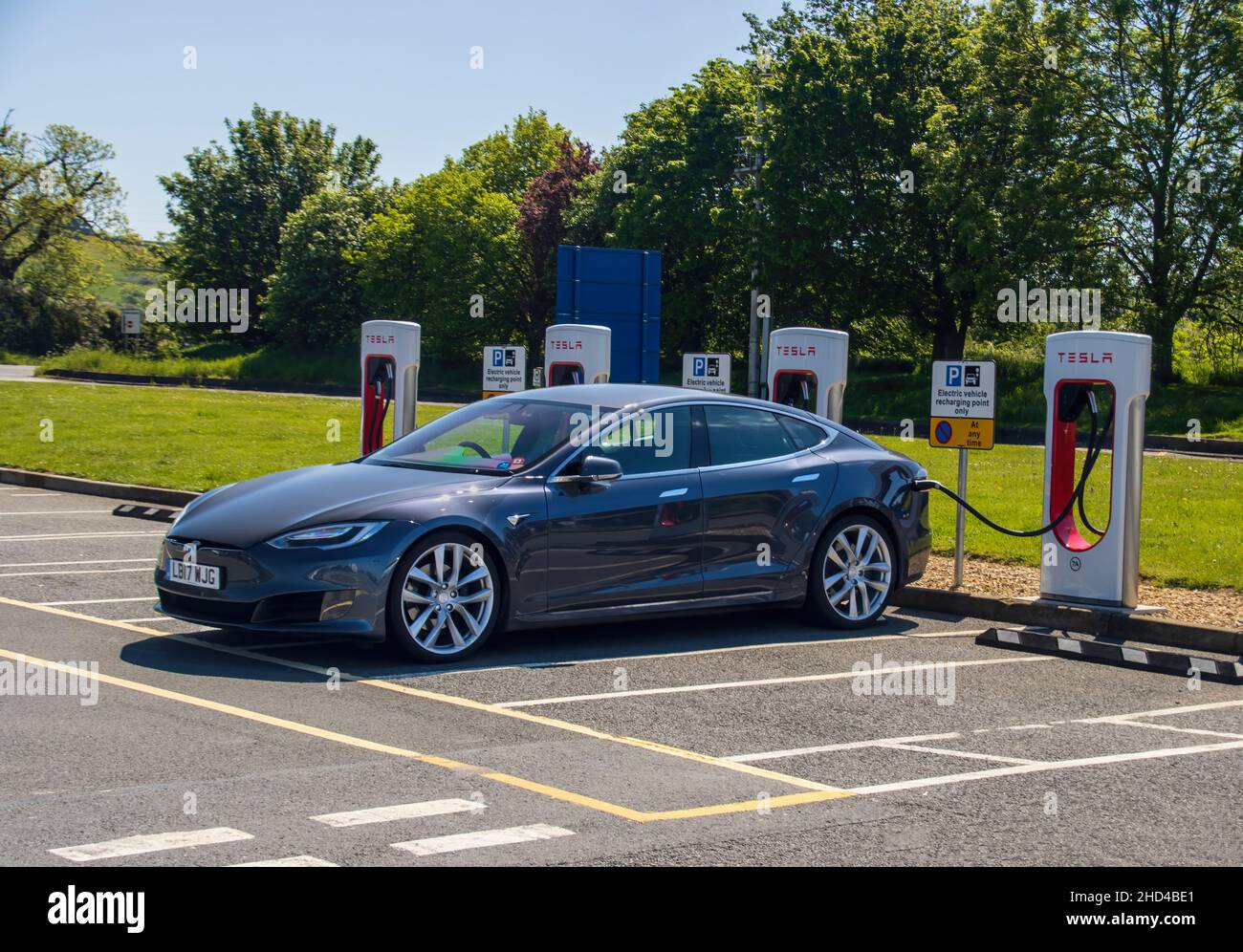 Grantham, Regno Unito - Maggio 30th 2021: Berlina Tesla collegata a un sovralimentatore in un'area di assistenza. Foto di alta qualità Foto Stock
