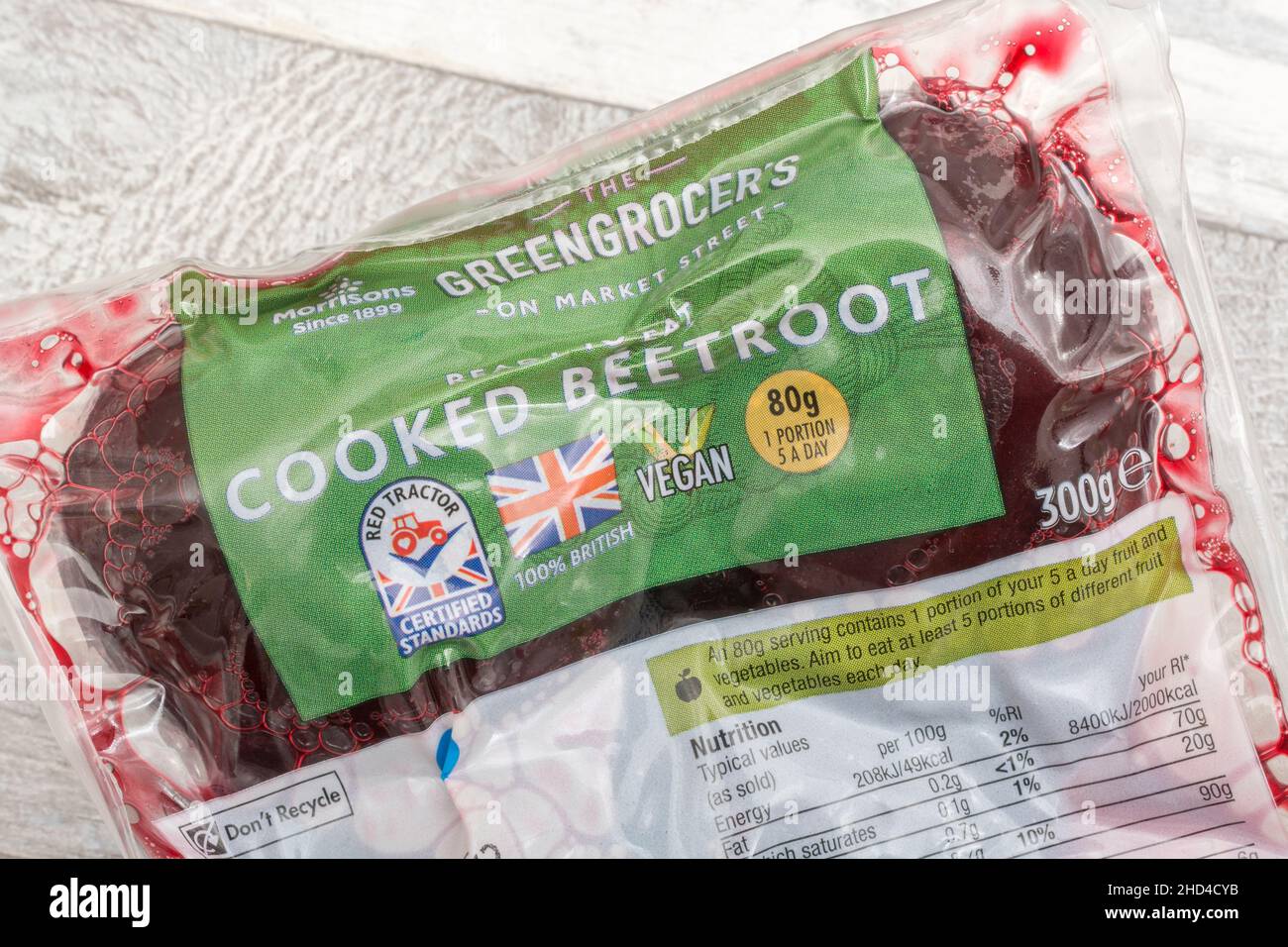 La barbabietola intera cotta con etichetta in plastica di Morrison, con confezione che mostra il logo Red Tractor, Union Jack for British farmed, il simbolo Vegan V. Foto Stock