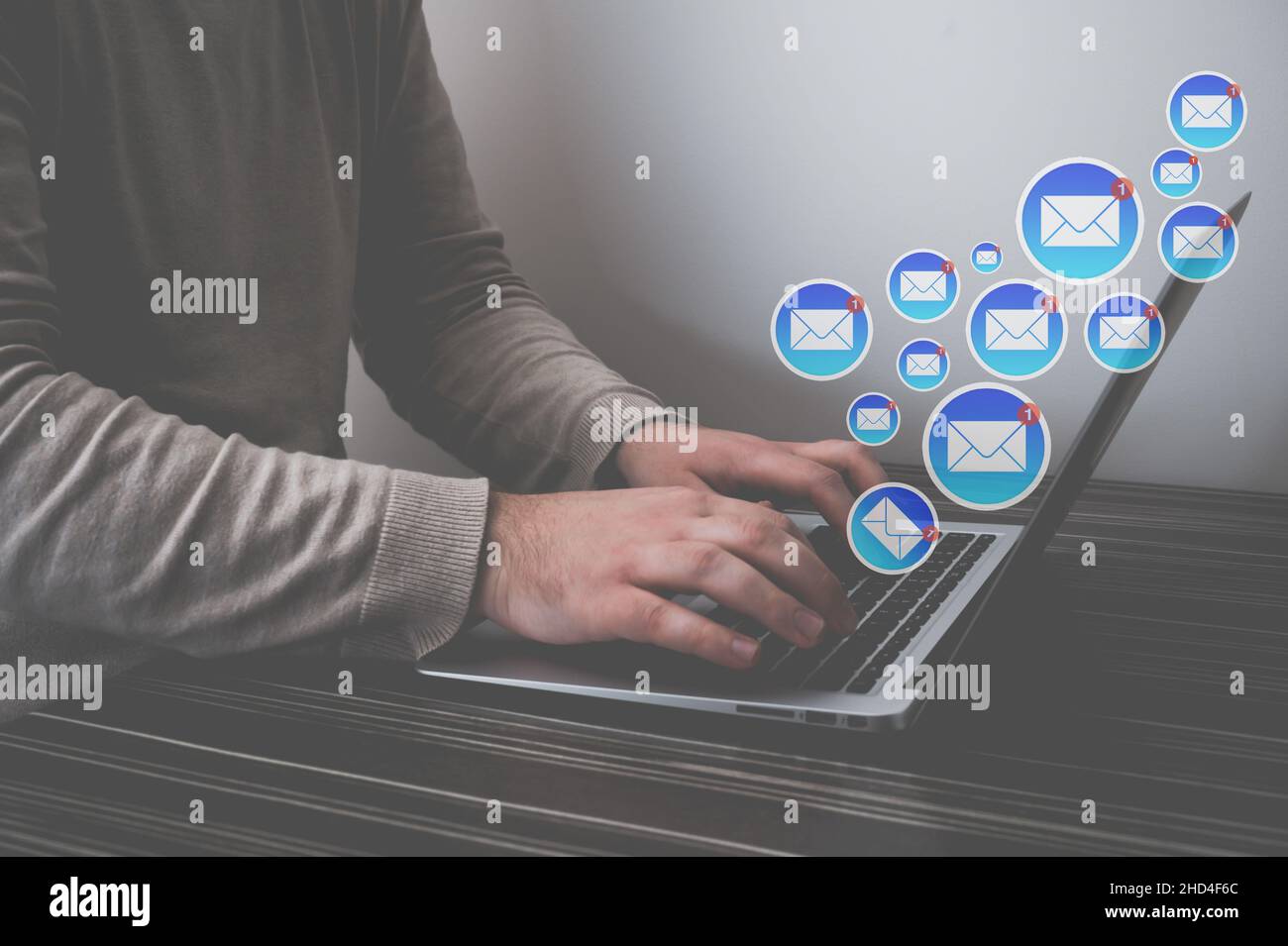 l'uomo invia e-mail su un computer in una scrivania interna, in primo piano Foto Stock