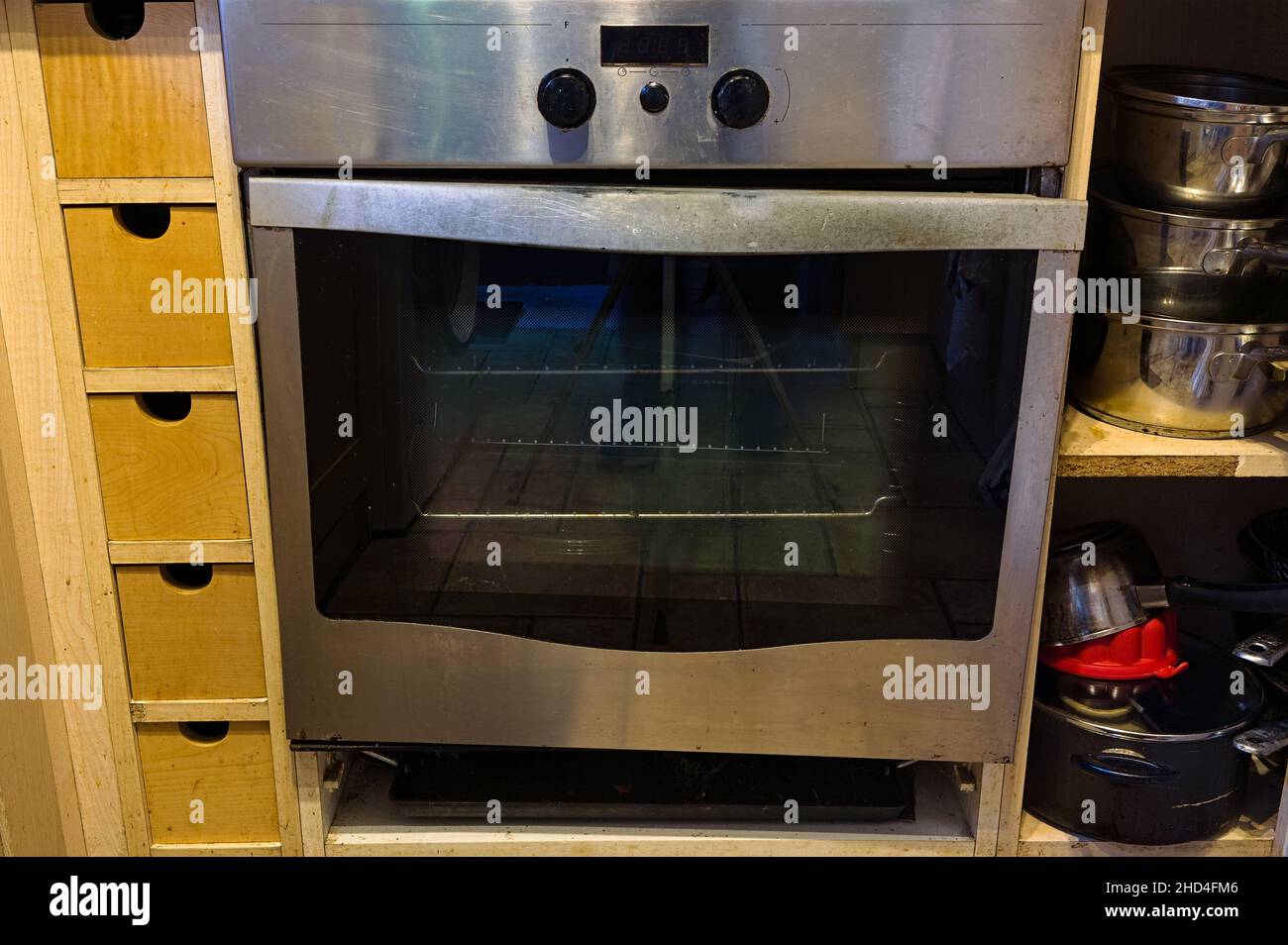 Porta rotta su un forno in acciaio inox in una cucina domestica Foto Stock