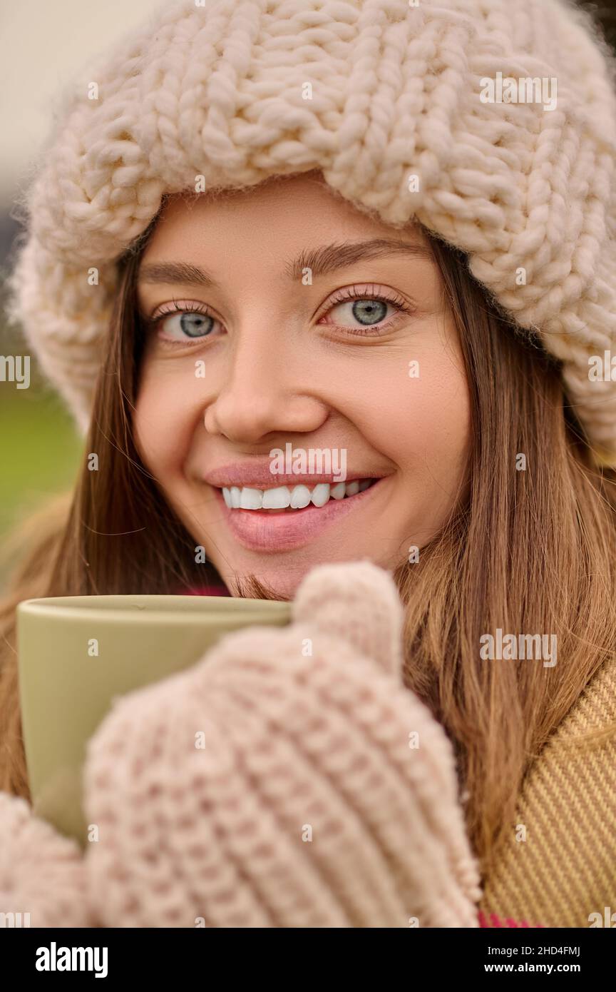 Ravvicinato donna con tazza guardando la fotocamera Foto Stock