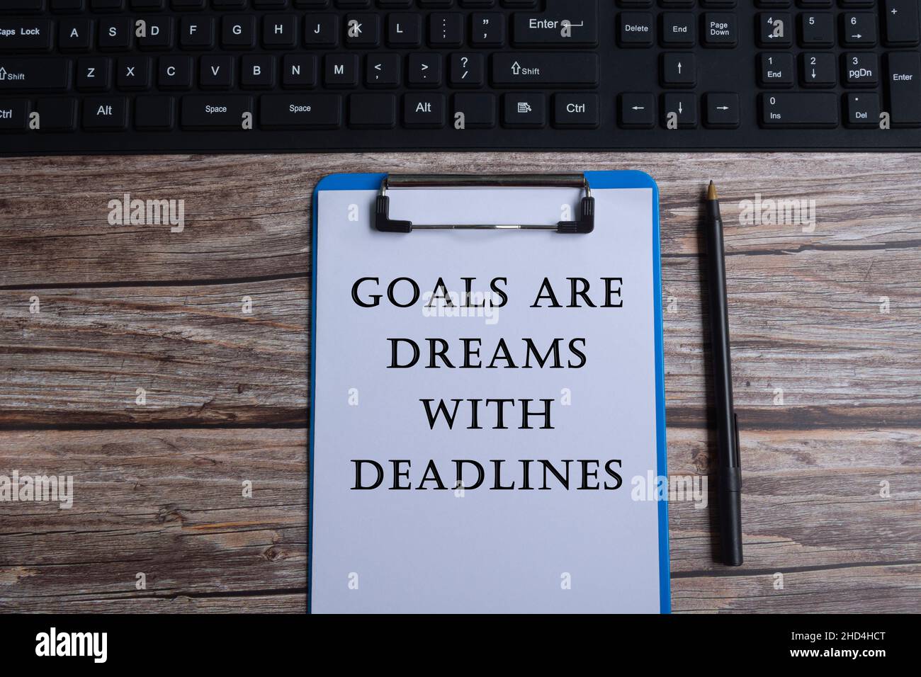 Citazione motivazionale scritta su appunti blu con tastiera e penna Foto Stock