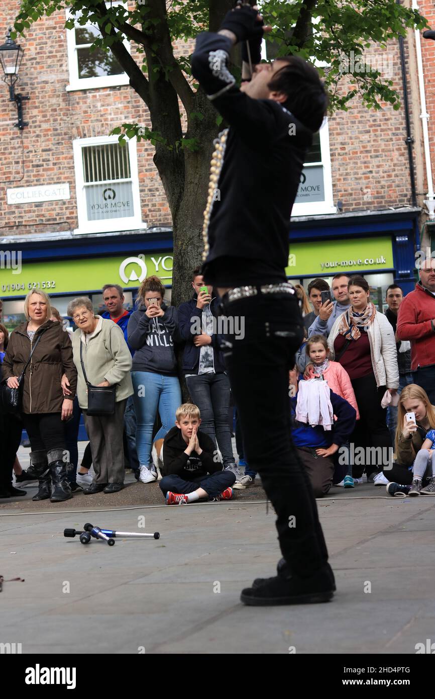 Primo piano di un artista di strada con una spada in gola nella città di York, Regno Unito Foto Stock