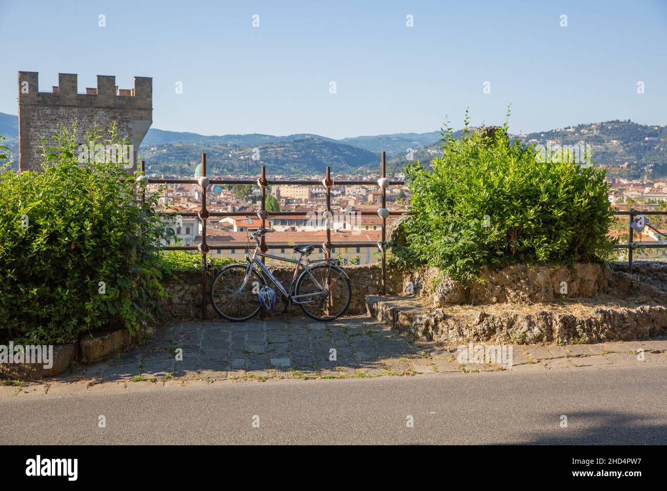 Parcheggiata la bicicletta su un marciapiede sotto un cielo blu in una giornata di sole Foto Stock