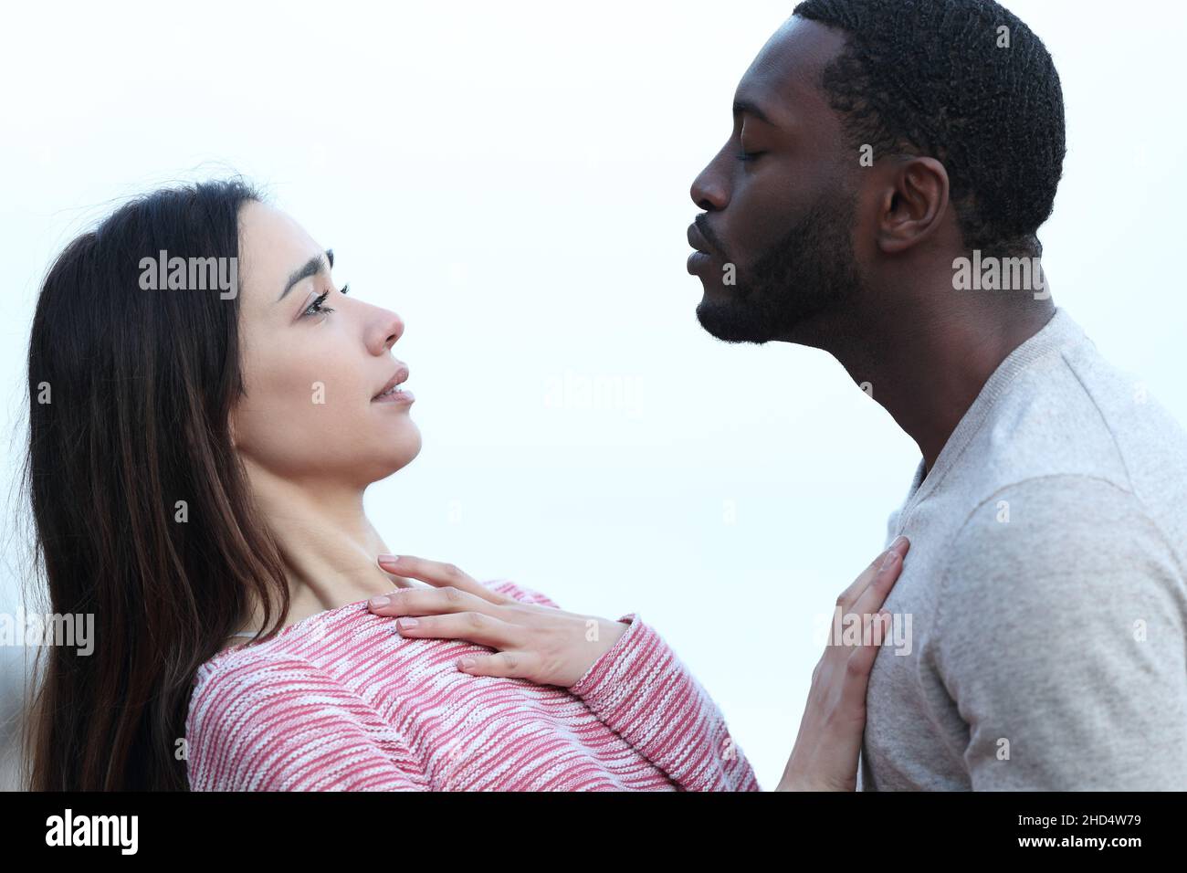 Ritratto di profilo di una donna che rifiuta un bacio da un uomo con pelle nera Foto Stock