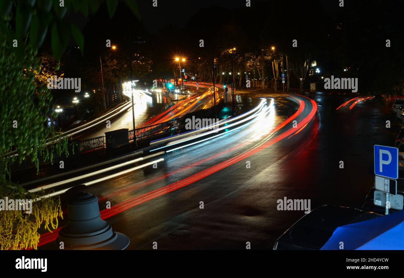 Paesaggio urbano notturno con luci e automobili. Foto Stock