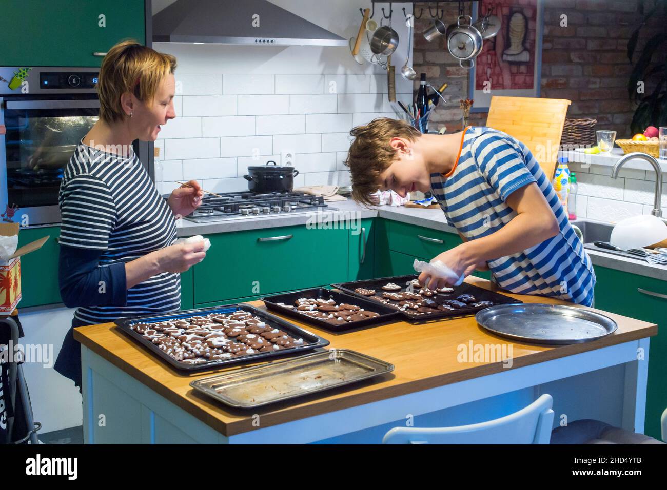 assistente adolescente della mamma in cucina Foto Stock