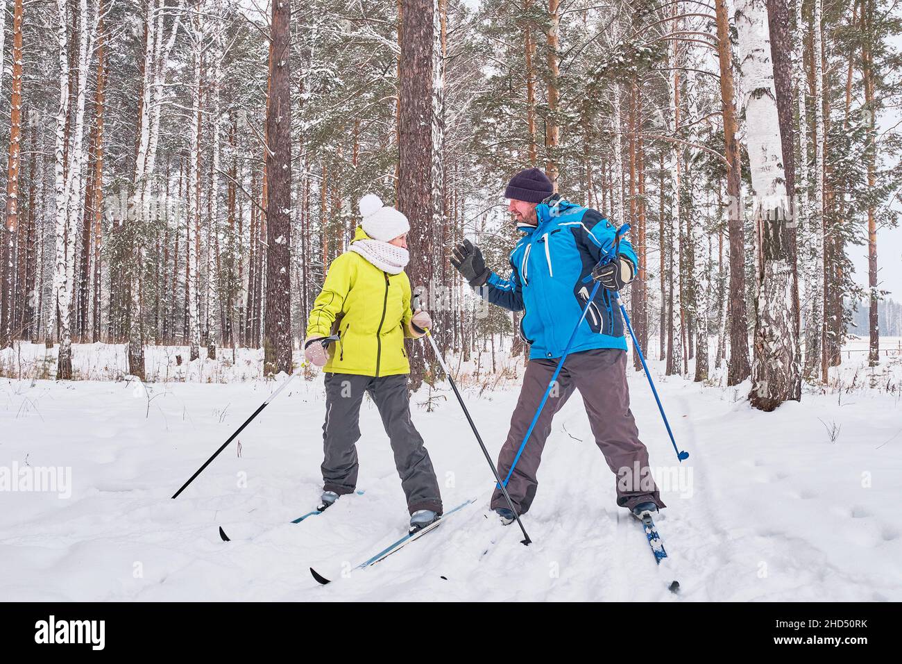 Litigare di coppia matura in inverno sono sci di fondo nella foresta innevata. Foto Stock